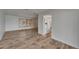 Open-concept living room with light wood flooring, a window, and a view to the kitchen at 6334 Cocoa Ln, Apollo Beach, FL 33572
