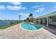 Backyard oasis with a sparkling pool, paved patio, and views of the waterfront creates a serene retreat at 6334 Cocoa Ln, Apollo Beach, FL 33572