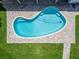 Aerial view shows a kidney-shaped pool surrounded by a brick patio and green grass at 6334 Cocoa Ln, Apollo Beach, FL 33572