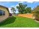 A spacious backyard with a well-kept lawn, bordered by a privacy fence, and mature landscaping, enhancing the property's appeal at 6530 68Th N St, Pinellas Park, FL 33781