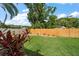 Spacious backyard with lush green lawn, a sturdy wooden fence, and vibrant landscaping, perfect for outdoor activities at 6530 68Th N St, Pinellas Park, FL 33781