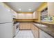 Well-lit kitchen with bright yellow walls, classic white appliances, and ample cabinet space, ready for culinary adventures at 6530 68Th N St, Pinellas Park, FL 33781