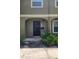 Townhouse front door with black door, mailbox, address, and landscaping at 7107 Hernando Ct, Tampa, FL 33615