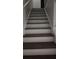 View of the staircase with painted white risers and wood look stair treads at 7107 Hernando Ct, Tampa, FL 33615