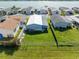Aerial view of a fenced backyard, showcasing green space and neighborhood with waterfront access at 8443 Fantasia Park Way, Riverview, FL 33578