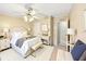 Cozy bedroom offers ceiling fan, bedside tables and lamps, soft decor and an adjacent doorway at 8443 Fantasia Park Way, Riverview, FL 33578