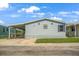 Charming single-story home featuring light blue siding, a covered carport, and a well-maintained lawn at 8443 Fantasia Park Way, Riverview, FL 33578