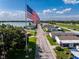 A view down the street showing well-maintained lawns and orderly homes with a large flag on display at 8443 Fantasia Park Way, Riverview, FL 33578