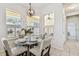 Bright dining area with pendant lighting, plantation shutters, and seating for four at 10203 Shadow Branch Dr, Tampa, FL 33647