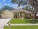 Charming single-story home with a well-manicured lawn, lush landscaping, and a two-car garage at 10203 Shadow Branch Dr, Tampa, FL 33647