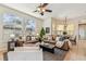 Bright living room with tile and wood flooring, ceiling fan, and views to the exterior at 10203 Shadow Branch Dr, Tampa, FL 33647