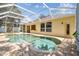 Screened in pool and spa surrounded by brick pavers and lush landscaping at 10203 Shadow Branch Dr, Tampa, FL 33647