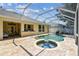 Backyard screened-in pool and spa with brick pavers and covered patio at 10203 Shadow Branch Dr, Tampa, FL 33647
