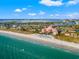 Scenic aerial view of a coastal city featuring a grand hotel, sandy beach, and clear blue ocean waters at 1109 Pinellas Bayway S # 306, Tierra Verde, FL 33715