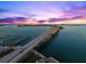 Stunning aerial view of a bridge at sunset, showcasing the waterway, city skyline, and colorful sky at 1109 Pinellas Bayway S # 306, Tierra Verde, FL 33715