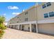 Charming two-story condo exterior with attached garage and well-maintained brick paved drive and flowering plants at 1109 Pinellas Bayway S # 306, Tierra Verde, FL 33715