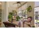 Charming screened patio featuring cozy wicker furniture, a ceiling fan, and various potted plants for a relaxing outdoor space at 1109 Pinellas Bayway S # 306, Tierra Verde, FL 33715