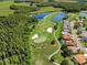 Aerial view showcasing golf course with ponds and sand traps adjacent to a residential community at 1115 Ashbourne Cir, Trinity, FL 34655