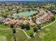 Aerial view of a residential community featuring a central pond and access to golf courses at 1115 Ashbourne Cir, Trinity, FL 34655