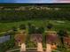 Expansive aerial view showcasing the property, nestled near lush greenery and a picturesque golf course at 1115 Ashbourne Cir, Trinity, FL 34655