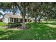 Beautifully landscaped backyard with mature trees providing shade and privacy, ideal for relaxation at 1115 Ashbourne Cir, Trinity, FL 34655