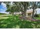 Serene backyard view with mature trees and landscaping overlooking the community golf course at 1115 Ashbourne Cir, Trinity, FL 34655