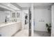 Bright bathroom with double sinks, tile flooring, and a walk-in shower with neutral tile at 1115 Ashbourne Cir, Trinity, FL 34655