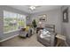 Bright, cozy room featuring two gray recliners, a ceiling fan, and a window with lots of light at 1115 Ashbourne Cir, Trinity, FL 34655