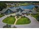 Aerial shot of community clubhouse, lush landscaping, golf course, and serene lake at 1115 Ashbourne Cir, Trinity, FL 34655