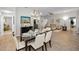 Open-concept dining room with stylish chandelier, seating for six, and views of living room at 1115 Ashbourne Cir, Trinity, FL 34655