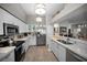 Modern kitchen with stainless steel appliances, white cabinets and a serving bar area at 1115 Ashbourne Cir, Trinity, FL 34655