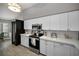 Well-lit kitchen featuring white cabinets, updated appliances, and ample countertop space at 1115 Ashbourne Cir, Trinity, FL 34655
