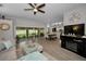 Open-concept living room features tile floors, ceiling fan, and sliding doors leading to the lanai at 1115 Ashbourne Cir, Trinity, FL 34655