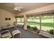 Sunroom featuring four chairs, sliding glass doors, and a ceiling fan to keep cool at 1115 Ashbourne Cir, Trinity, FL 34655