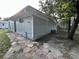 Backyard with textured gray siding on the house, stone pavers, a small air conditioner and well-maintained lawn at 12009 Washington St, Seffner, FL 33584