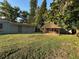 A large, well maintained backyard featuring an enclosed gazebo and an external shed, enclosed by mature trees at 12009 Washington St, Seffner, FL 33584