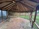Rustic gazebo with a brown roof and a stone paver floor sits nestled in the spacious backyard of this beautiful home at 12009 Washington St, Seffner, FL 33584