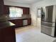 The kitchen features a stainless steel refrigerator and stylish dark wood cabinetry at 12009 Washington St, Seffner, FL 33584