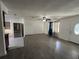 Open-concept living room with hardwood floors, ceiling fan, and natural light at 12009 Washington St, Seffner, FL 33584