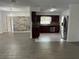 Open-concept layout featuring hardwood-style floors, a stacked stone accent wall, and a modern kitchen with stainless appliances at 12009 Washington St, Seffner, FL 33584