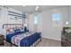 A bright bedroom featuring a patterned quilt, blue accents, natural light, and a cozy, inviting atmosphere at 12824 Wanderlust Pl, Parrish, FL 34219