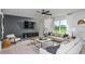 Bright living room with modern decor, a large window with lake views, a ceiling fan, and neutral-toned furniture at 12824 Wanderlust Pl, Parrish, FL 34219