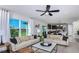 Bright open-concept living room featuring a large window, two couches, modern decor, and seamlessly connected kitchen at 12824 Wanderlust Pl, Parrish, FL 34219