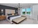 A serene main bedroom featuring a tufted headboard, bench, and a view of the outdoors through bright windows at 12824 Wanderlust Pl, Parrish, FL 34219
