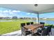 Covered patio with dining furniture overlooking a peaceful lake and landscaped backyard at 12824 Wanderlust Pl, Parrish, FL 34219
