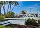 The Pasadena Cove community sign features palm trees, plants and a flying bird statue at 1324 Pasadena S Ave # 501, South Pasadena, FL 33707