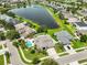 Beautiful aerial view of a home with a private pool, lush landscaping, and a lake nearby at 13728 Artesa Bell Dr, Riverview, FL 33579