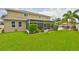 Expansive backyard with a manicured lawn, a screened patio, and ample space for outdoor activities at 13728 Artesa Bell Dr, Riverview, FL 33579