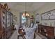 Formal dining room featuring a wood table set for six, china cabinet, and elegant chandelier at 13728 Artesa Bell Dr, Riverview, FL 33579