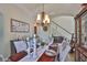 Dining room featuring a wood table set for six, chandelier, and staircase in background at 13728 Artesa Bell Dr, Riverview, FL 33579